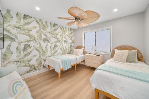 a bedroom with two beds and a ceiling fan at Luxury Villa 3 Blocks from the Beach with a Pool, Fire Pit and Outdoor Oasis in Cape Canaveral
