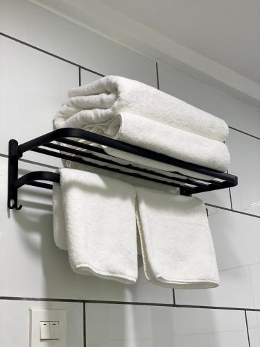 a group of towels on a towel rack in a bathroom at Le Bijou Chic in the Heart of Saigon Charm with VIEW in Ho Chi Minh City