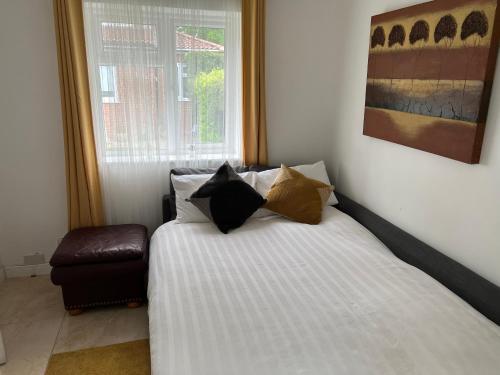 a bedroom with a bed with pillows and a window at Dannifar Guest House in London