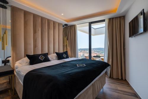 ein Schlafzimmer mit einem großen Bett und einem großen Fenster in der Unterkunft Luxury Villa Favela with heated pool in Trogir