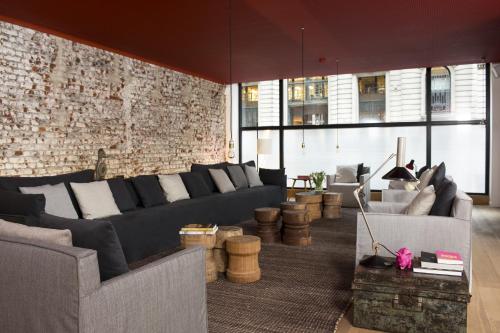 a living room with a couch and a brick wall at 9Hotel Central in Brussels