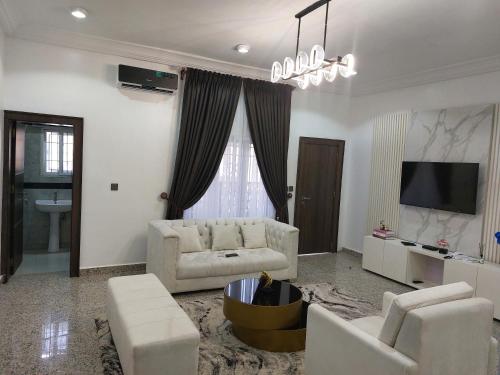 ein Wohnzimmer mit einem Sofa und einem TV in der Unterkunft Officer Condo Apartments in Yanyan