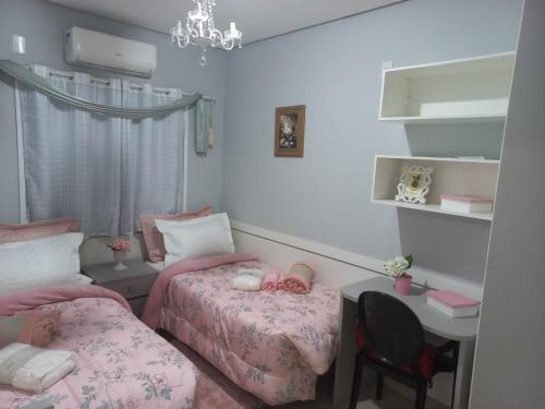 a bedroom with two beds and a desk and a table at Hotel Palace in Porto Alegre