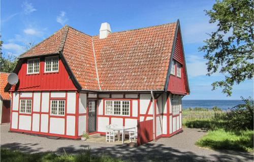 a red and white house with a table in front of it at Awesome Home In Gudhjem With Wifi in Gudhjem