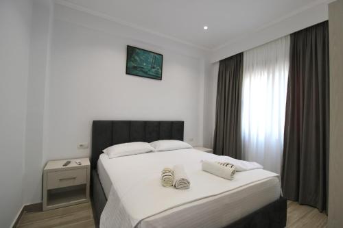 a bedroom with a bed with two shoes on it at Garden Vila Ermali in Ksamil