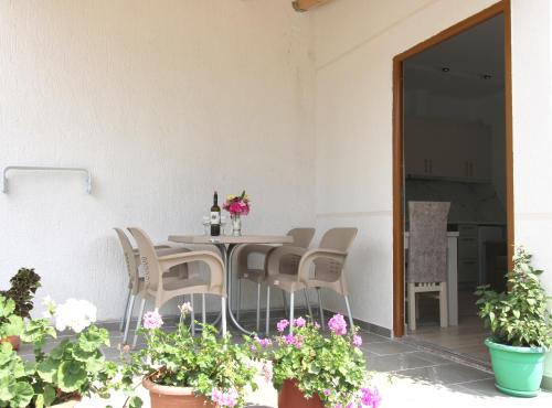a patio with a table and chairs and flowers at Garden Vila Ermali in Ksamil