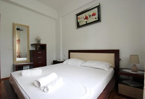 a bedroom with a bed with two towels on it at Garden Vila Ermali in Ksamil