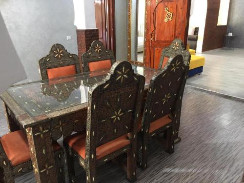 drewniany stół z krzesłami i szklanym dachem w obiekcie VILLA TAZARZIT w Marakeszu