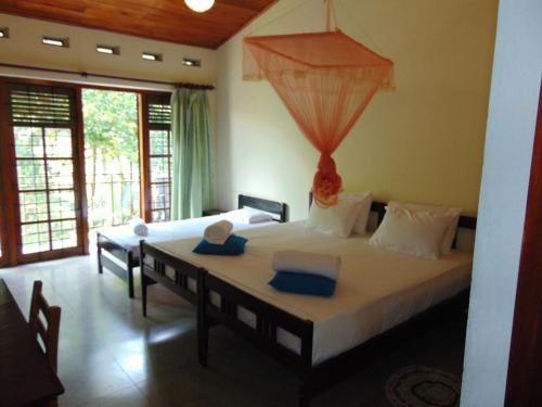 um quarto com uma cama grande e toalhas azuis em KOON COTTAGE em Kandy