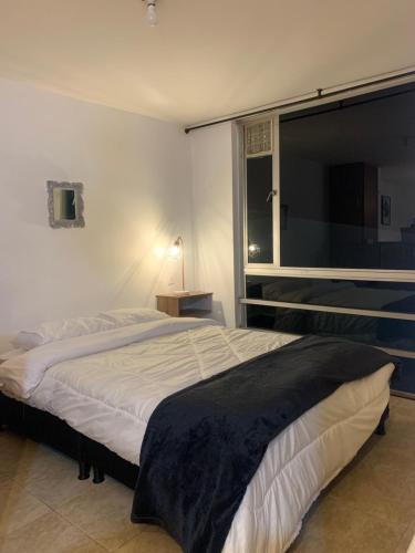 Un dormitorio con una cama grande y una ventana en Apartamento en Manizales, en Manizales