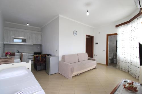 a living room with a couch and a kitchen at Garden Vila Ermali in Ksamil