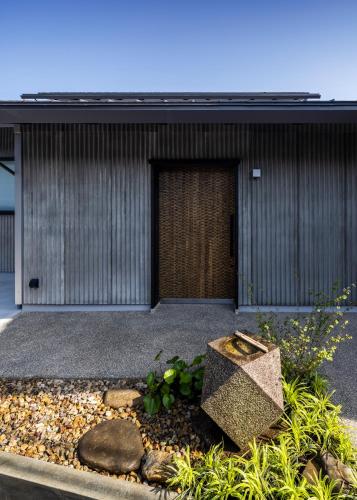 a garden in front of a building with a door at casa網野 in Kyotango