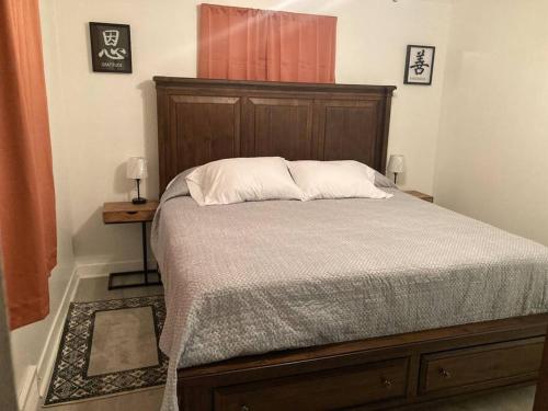 - un lit avec une tête de lit en bois dans une chambre dans l'établissement Comfortable and quiet apartment minutes from downtown in Thomasville!, à Thomasville