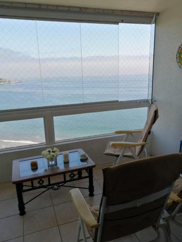 uma sala de estar com mesa e cadeiras e vista para o oceano em Departamento Costa Quilén, Puchuncaví. (10 min de Maitencillo) em Valparaíso