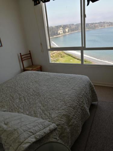 um quarto com uma cama e uma grande janela em Departamento Costa Quilén, Puchuncaví. (10 min de Maitencillo) em Valparaíso