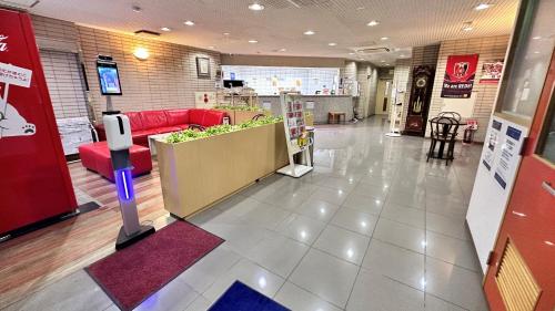 um lobby de uma loja com um sofá vermelho em Hotel New Saitama em Saitama
