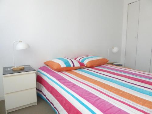 - une chambre avec un lit et une commode avec deux oreillers dans l'établissement Superbe T2 rénové face mer avec parking, proche plage et commerces, Les Sables d'Olonne - FR-1-325-69, à Les Sables-dʼOlonne