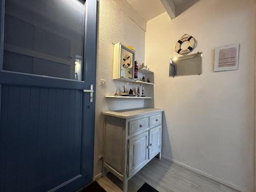 La salle de bains est pourvue d'un lavabo et d'une porte bleue. dans l'établissement Appartement duplex à Erdeven avec piscine, proche plage, 4 couchages, équipements complets - FR-1-397-5, à Erdeven