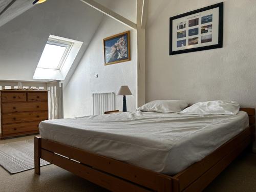 une chambre avec un grand lit avec une fenêtre dans l'établissement Appartement duplex à Erdeven avec piscine, proche plage, 4 couchages, équipements complets - FR-1-397-5, à Erdeven