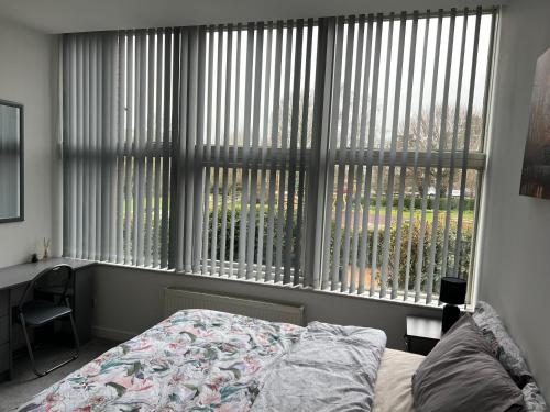 a bedroom with a bed and a large window at 2 Bedroom Flat Ground Floor in Town Center in Wellingborough