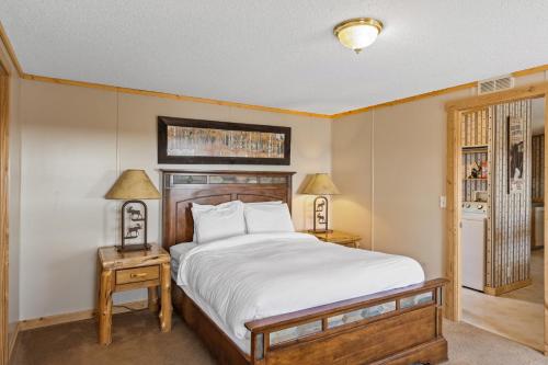 a bedroom with a large bed and two tables with lamps at Alpine #3 in West Yellowstone