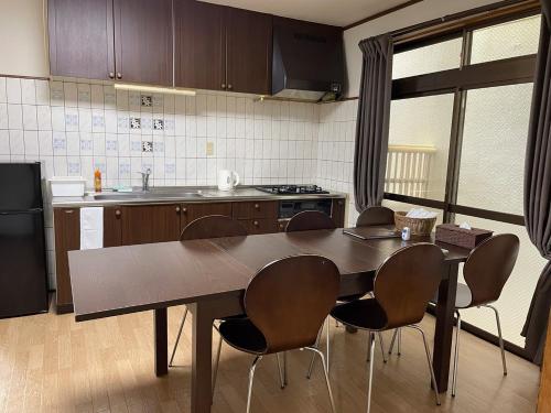 una cocina con una gran mesa de madera y sillas en Hiroshima Danbara LiBPLUS en Hiroshima