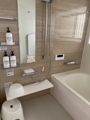 a bathroom with a shower and a toilet and a tub at Hiroshima Danbara LiBPLUS in Hiroshima