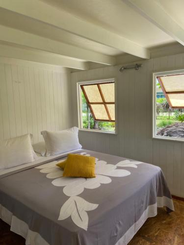 Temae的住宿－Great House BY Manaeva Lodge，一张大床,位于带两个窗户的房间