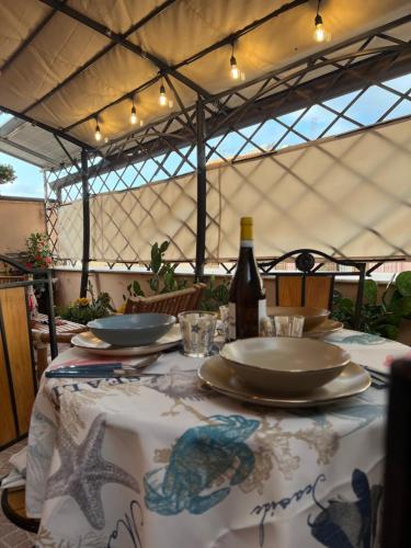 a table with a table cloth with a bottle of wine at Delfino House in Terrasini