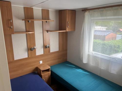 une petite pièce avec un lit et une fenêtre dans l'établissement Mobilhome familial avec piscine, tennis et jeux à Blonville-sur-Mer - FR-1-712-60, à Blonville-sur-Mer
