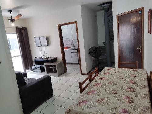 a living room with a table and a living room with a couch at Apartamento de Praia no Centro in Itapema
