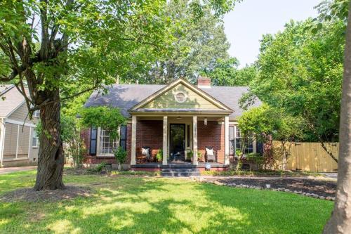 a brick house with a tree in the yard at J Birds' Cottage Midtown Memphis in Memphis