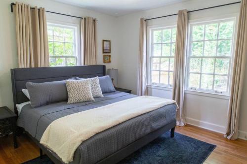 a bedroom with a large bed with two windows at J Birds' Cottage Midtown Memphis in Memphis