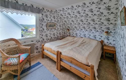 a bedroom with a bed and a chair and a window at Awesome Apartment In Kungshamn With House Sea View in Kungshamn