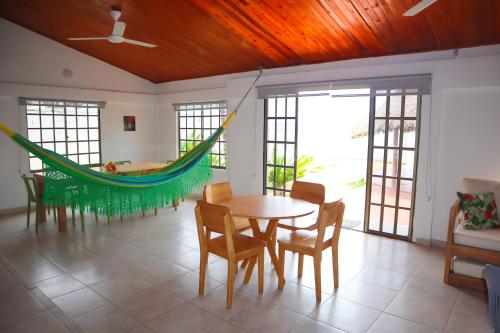 a room with a hammock and a table and chairs at Cabaña Macondo in Coveñitas