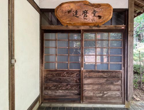 una entrada a un edificio con puerta de madera en Kiyo's Gokokuen "Tatsumado" - Vacation STAY 77728v, en Kasama