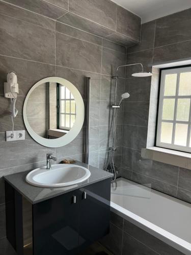 uma casa de banho com um lavatório e um espelho em White Guest Fátima em Fátima