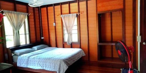 a bedroom with a bed and two windows at Najjamee Bungalows in Ko Yao Noi