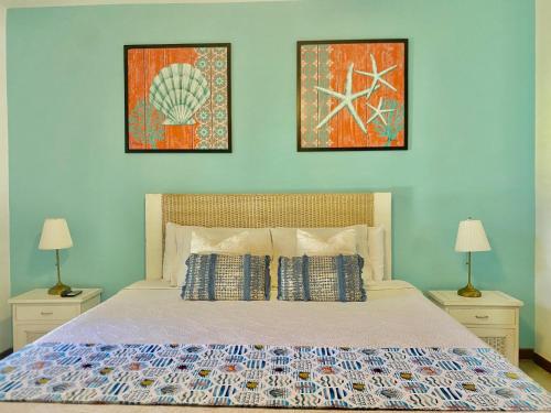 a bedroom with a bed with two lamps and two pictures at Stunning Beachfront Condo With Private Beach, Las Terrenas-El Limón in El Limón