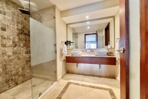 a bathroom with two sinks and a shower at New! Beachfront Lux Condo With Private Jacuzzi in Punta Cana