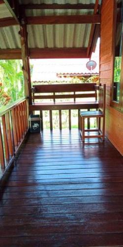 a wooden porch with a bench and a table at Najjamee Bungalows in Ko Yao Noi