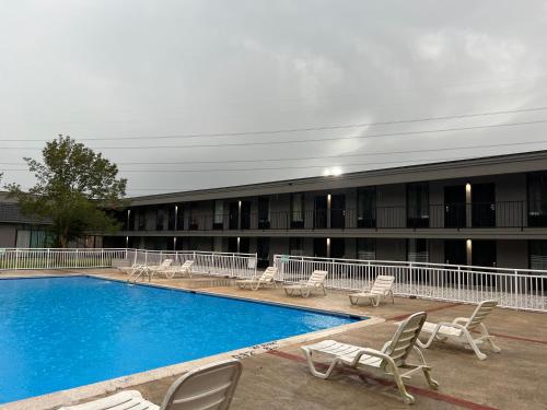 un hotel con piscina, sillas y un edificio en The Nest Hotel Suffolk, en Suffolk