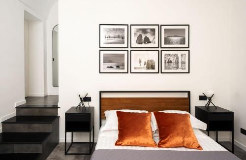 a bedroom with a bed with four pictures on the wall at Casa800 in Capri