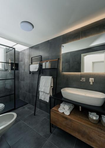 a bathroom with a sink and a tub and a mirror at Casa800 in Capri