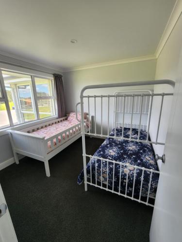 two bunk beds in a room with a window at Country Hamptons Coastal Chic with Heated Pool in Ruakaka