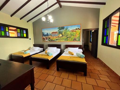 two beds in a room with stained glass windows at Hotel Campestre Los Mangos in Quimbaya