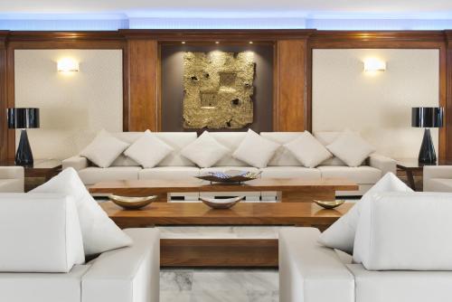 a living room with a white couch and a table at Elba Motril Beach & Business Hotel in Motril