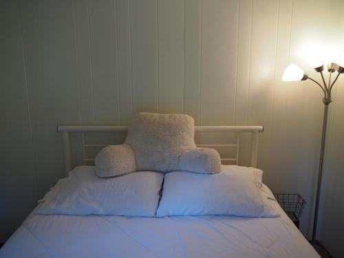 Bett mit zwei Kissen neben einer Lampe in der Unterkunft Sleeping Bear Riverside Cabins - Cabin #4 in Honor