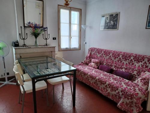 un salon avec un canapé rouge et une table en verre dans l'établissement Appartement Cannes à quelques pas de la mer, de la Croisette et du Palais des Festivals, à Cannes