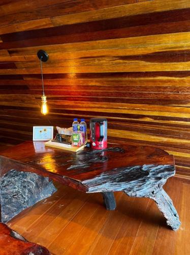 a table in a room with a wooden wall at SANKARA GARDEN in Pantai